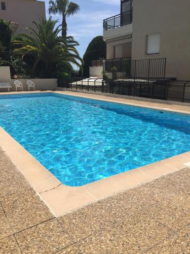 une grande piscine bleue à côté d'un immeuble dans l'établissement Happyfew la terrasse de Selfina, à Nice