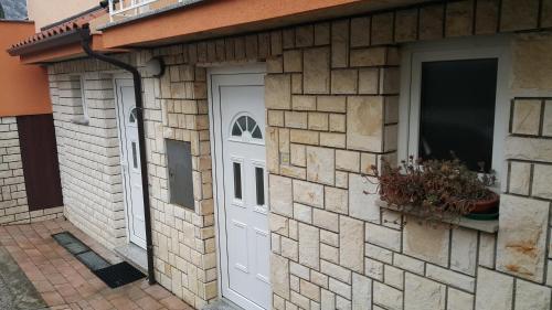 a brick building with a white door and a window at Love 2 Solkan in Nova Gorica