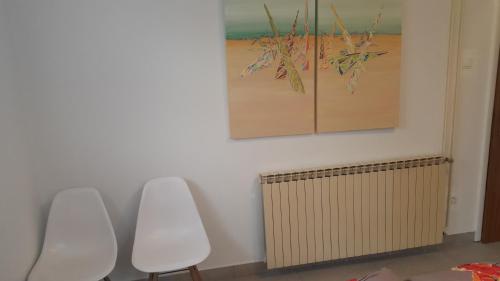 a room with two white chairs and a painting at Love 2 Solkan in Nova Gorica