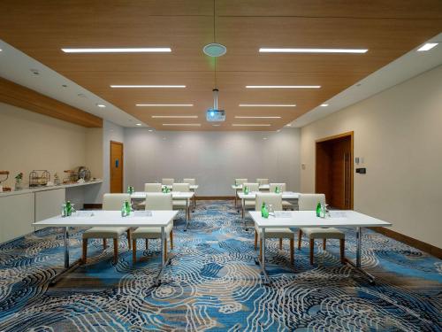 a conference room with white tables and white chairs at Novotel Jazan in Jazan
