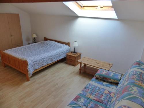 - une chambre avec un lit, un canapé et une lucarne dans l'établissement CAPBRETON Résidence LE BOSQUET AUX ECUREUILS Villa avec piscine en copropriété, à Capbreton