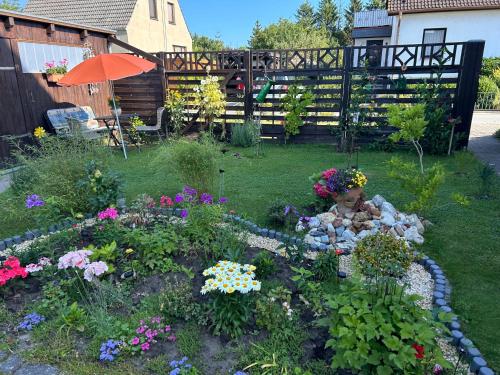 un jardín con un ramo de flores y una sombrilla en Ferienwohnung Zum Anmselgarten, en Ribnitz-Damgarten