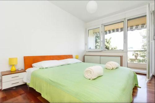 a white bedroom with two beds and two windows at Apartment Put Meja in Split