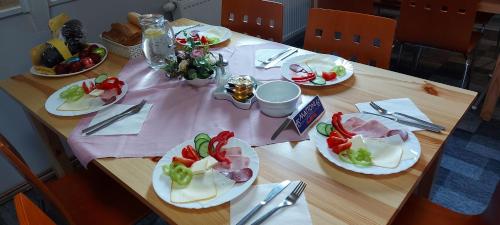Una mesa de madera con platos de comida encima. en Penzion Svojanov, en Svojanov