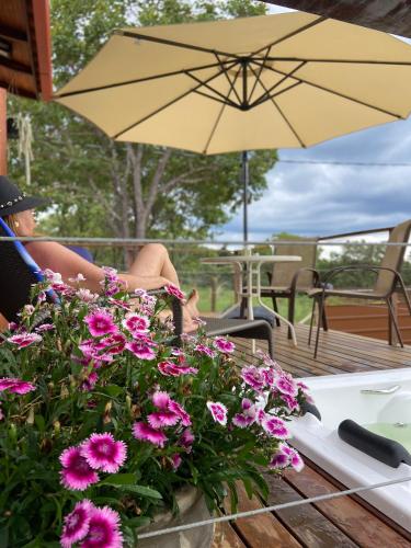a person sitting at a table with a yellow umbrella at Chalé Makar in Serra do Cipo