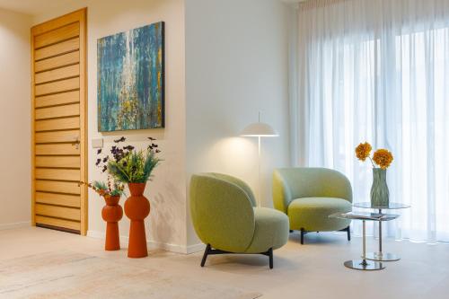 a living room with chairs and a table and a painting at Hera Rooms and Suites in Agrigento
