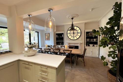 a kitchen and dining room with a large clock on the wall at Stunning Town House in City Centre- Free Parking! in Bath