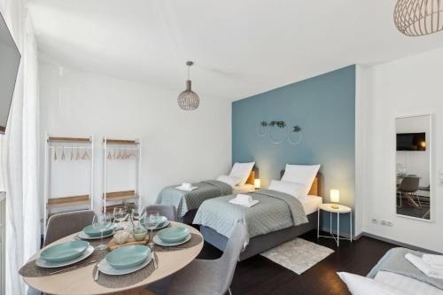 a bedroom with two beds and a table with plates on it at Zentral gelegenes Cityapartment in Neustadt an der Weinstraße in Neustadt an der Weinstraße
