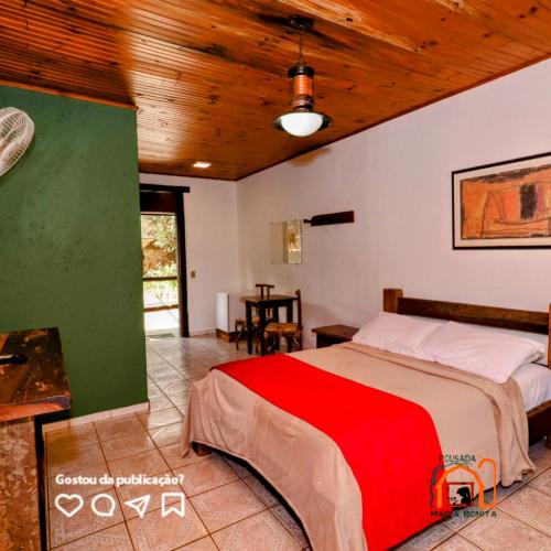 a bedroom with a bed and a wooden ceiling at Pousada Maria Bonita in Macacos