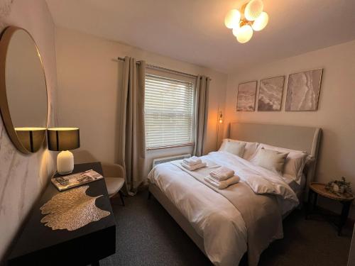 a bedroom with a bed with a mirror and a window at 2 Bedroom Apartment 11 Minutes From Stansted Airport in Great Dunmow