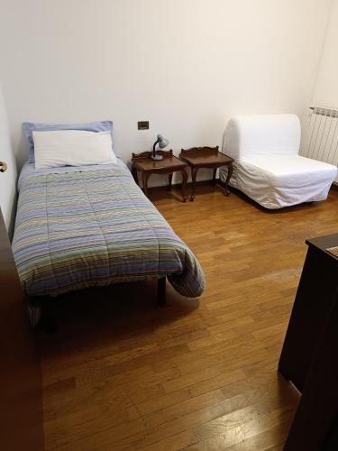 a bedroom with two beds and a wooden floor at RELAX locazione turistica in Ceregnano