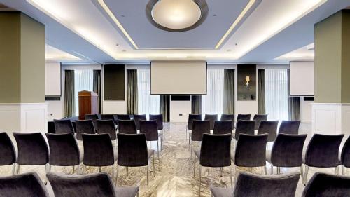 a conference room with chairs and a podium at Hotel Colón Gran Meliá - The Leading Hotels of the World in Seville