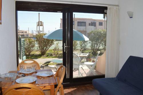 a table with a blue umbrella in a living room at Appart Studio 2 couchages PORT LEUCATE NATURISME PL010-423 in Leucate-Plage