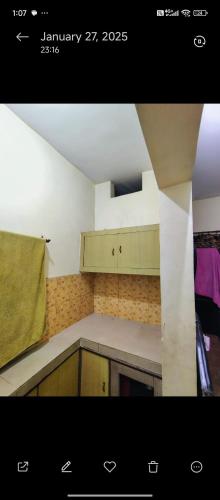 a small kitchen with a counter top and a kitchenestamp at Kumbh room in Muthiganj