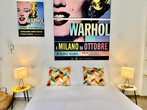 a bedroom with a bed and two posters on the wall at Urban Nest Apartments in Milan