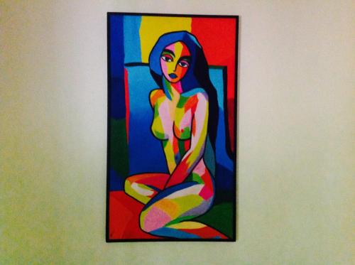 a painting of a woman is hanging on a wall at Casa Manglar Villa in Puerto Jiménez
