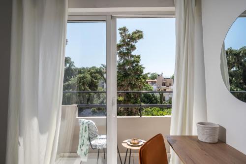 a room with a large window with a table and chairs at Senaon Urban Living City Center in Heraklio Town