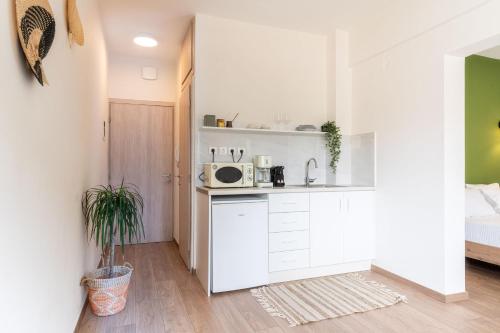 a white kitchen with a microwave on a counter at Senaon Urban Living City Center in Heraklio Town