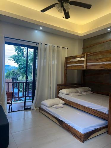 two bunk beds in a room with a balcony at Mountain View at Fuji St Antipolo in Antipolo