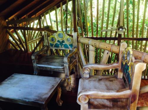 two chairs and a bench sitting in a room at Casa Manglar Villa in Puerto Jiménez