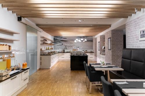 a large kitchen with a dining room with tables and chairs at Hotel Shuum Boutique - Destigo Hotels in Kołobrzeg