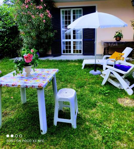 a table and chairs and an umbrella on a yard at Appartamento GALY Spoleto in San Venanzia