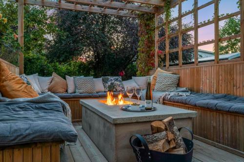eine Terrasse mit Sofas und einem Tisch mit einer Feuerstelle in der Unterkunft Family-Friendly Retreat Near beach, Malmö & Lund in Åkarp