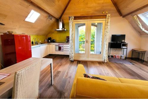 a living room with a yellow couch and a kitchen at Studio Nok bij Den Bosch in Den Dungen
