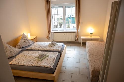 a small room with two beds and a window at Ferienwohnung & Apartment Am Steinbrunnen in Brauneberg