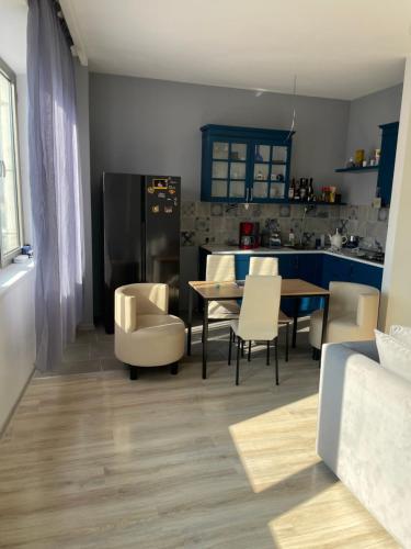Una cocina y un comedor con mesa y sillas. en Cosmo Apartment, en Tiflis