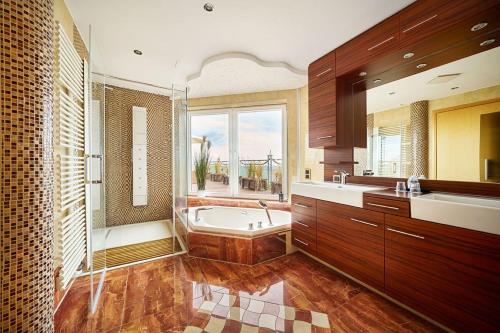 ein großes Badezimmer mit Badewanne und Waschbecken in der Unterkunft Strandhotel Prinz von Preussen in Zinnowitz