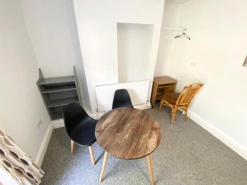 une pièce avec une table et des chaises en bois dans l'établissement Budget room 10min Walk to Swansea Centre 1, à Swansea
