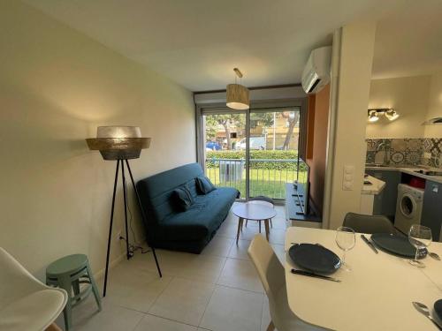 un salon avec un canapé bleu et une table dans l'établissement Appartement Studio cabine 4 couchages ARGELES SUR MER AR020-037, à Argelès-sur-Mer