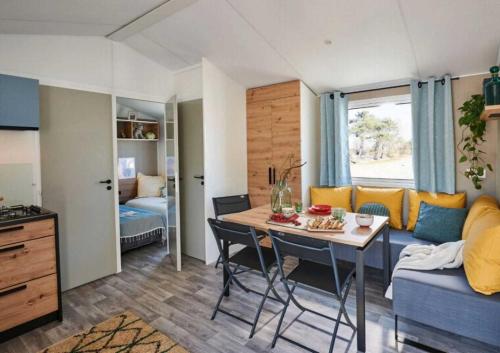 un salon avec une table et un canapé dans l'établissement Camping - Parc aquatique - ccaghdi, à Saint-Jean-de-Monts