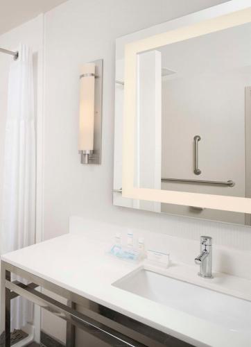 a white bathroom with a sink and a mirror at Hilton Garden Inn San Antonio Downtown Riverwalk in San Antonio