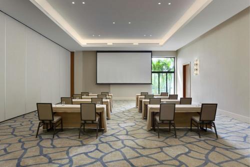 a conference room with tables and chairs and a white screen at The Santa Maria, a Luxury Collection Hotel & Golf Resort, Panama City in Panama City
