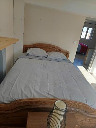 a bedroom with a bed with a wooden bed frame at Appartement calme, frais à louer, nouvellement repeint, emplacement stratégique, proche de toutes commodités, de l'autoroute, valenciennes, lille, Belgique, wifi, Netflix, parking Gratuits in Raismes