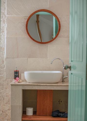 a bathroom with a sink and a mirror at Quma Boutique Hotel - Adults Only in Gili Trawangan
