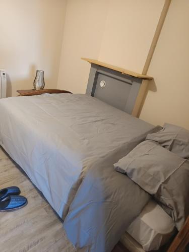 a bedroom with a large bed with a wooden headboard at Appartement calme, frais à louer, nouvellement repeint, emplacement stratégique, proche de toutes commodités, de l'autoroute, valenciennes, lille, Belgique, wifi, Netflix, parking Gratuits in Raismes