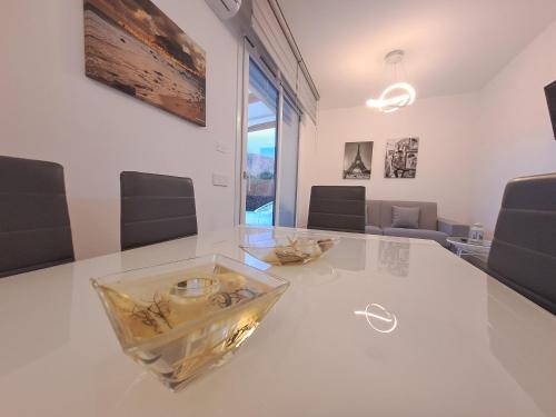 a white table with a glass bowl on top of it at Villa Elios Adriana with pool by Casa in mente in Lascari