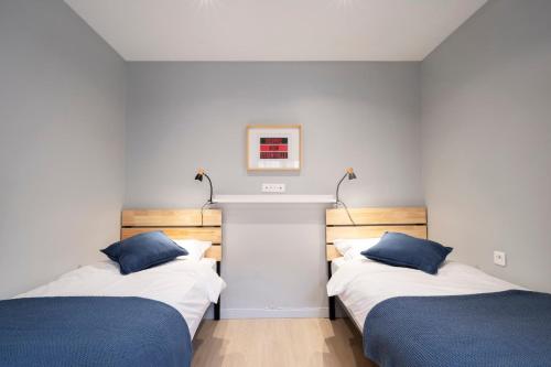 deux lits côte à côte dans une pièce dans l'établissement Les Ponts, à Nancy
