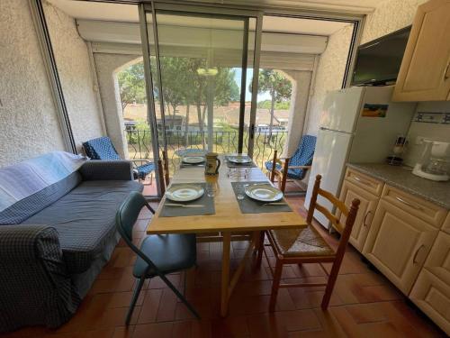 - une cuisine avec une table et un canapé dans une chambre dans l'établissement Appartement deux pièces cabine- Argelès sur mer AR155-024, à Argelès-sur-Mer