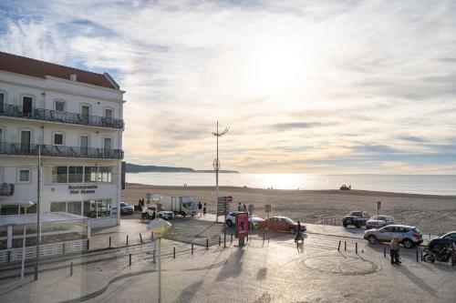 a parking lot with cars parked on the beach at By the Sea - Nazaré in Nazaré