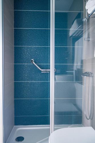 a bathroom with a shower with blue tiles at By the Sea - Nazaré in Nazaré