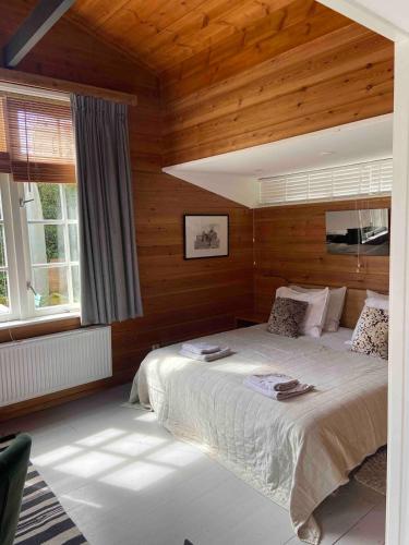 a bedroom with a bed in a room with wooden walls at t Ateliertje Noort in Bergen