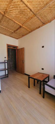 an empty room with a wooden table and a bed at Roha Family Gust House in Lalībela