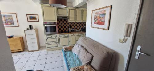 un salon avec un canapé dans une cuisine dans l'établissement Studio Les pieds dans l 'eau, à Collioure