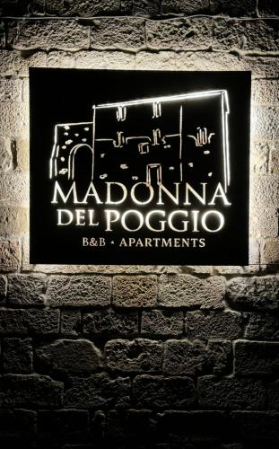 a sign on a brick wall with a sign for malibu del popcorn at Madonna Del Poggio CAV in Scarlino