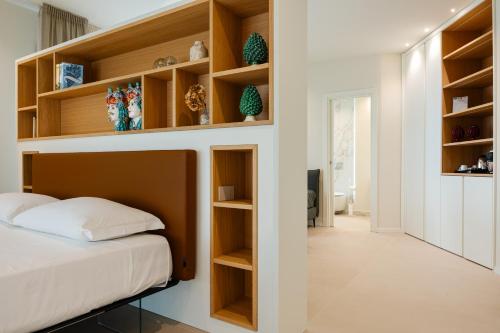a bedroom with wooden shelves and a bed at Hera Rooms and Suites in Agrigento