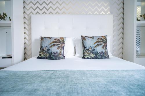 a bedroom with a white bed with two pillows at By the Sea - Nazaré in Nazaré